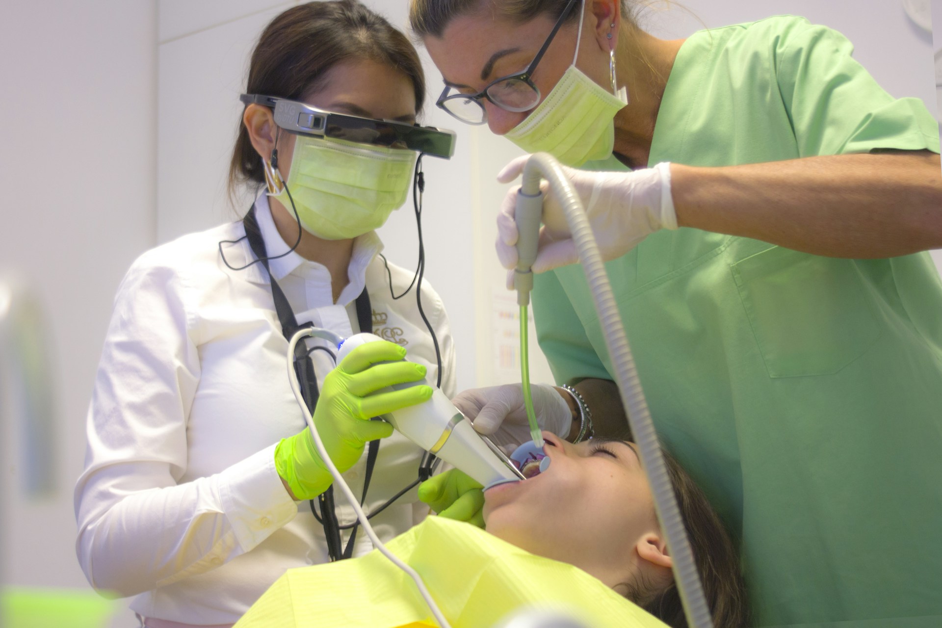 zwei Frauen kontrollieren die Zähne einer Patientin