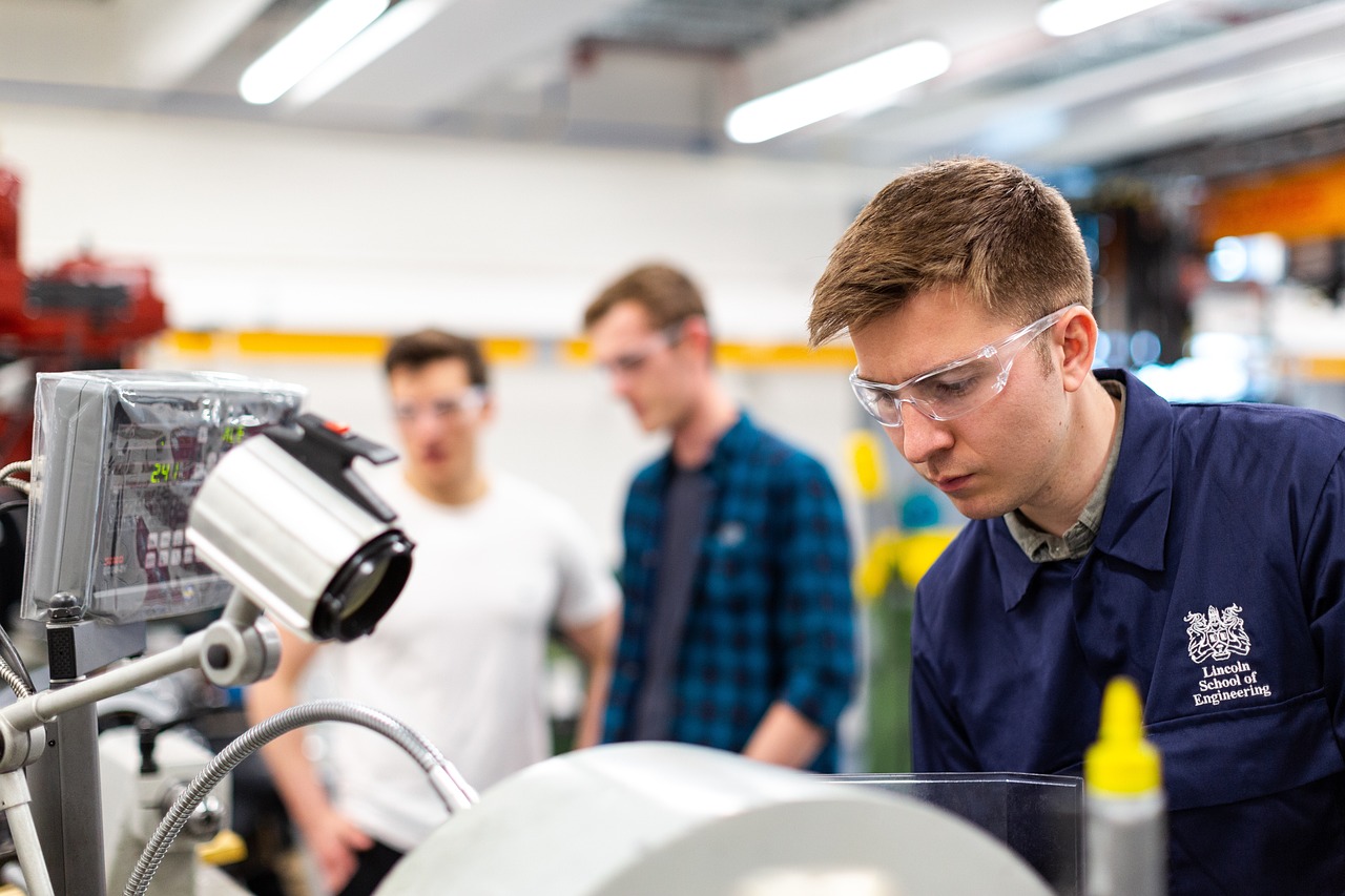 junger Mann steht vor Industriemaschine