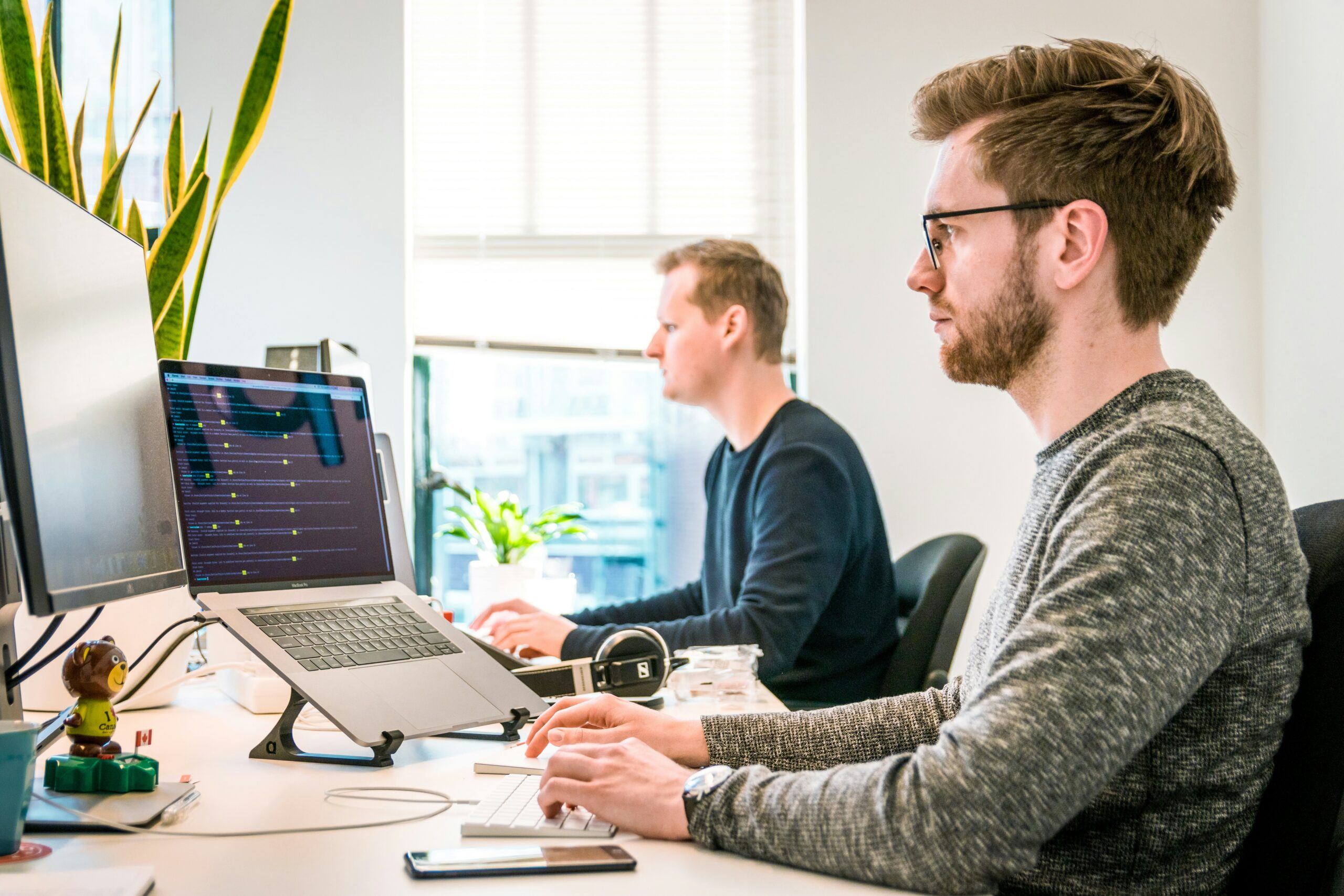 junger Mann sitzt am Schreibtisch und arbeitet am PC