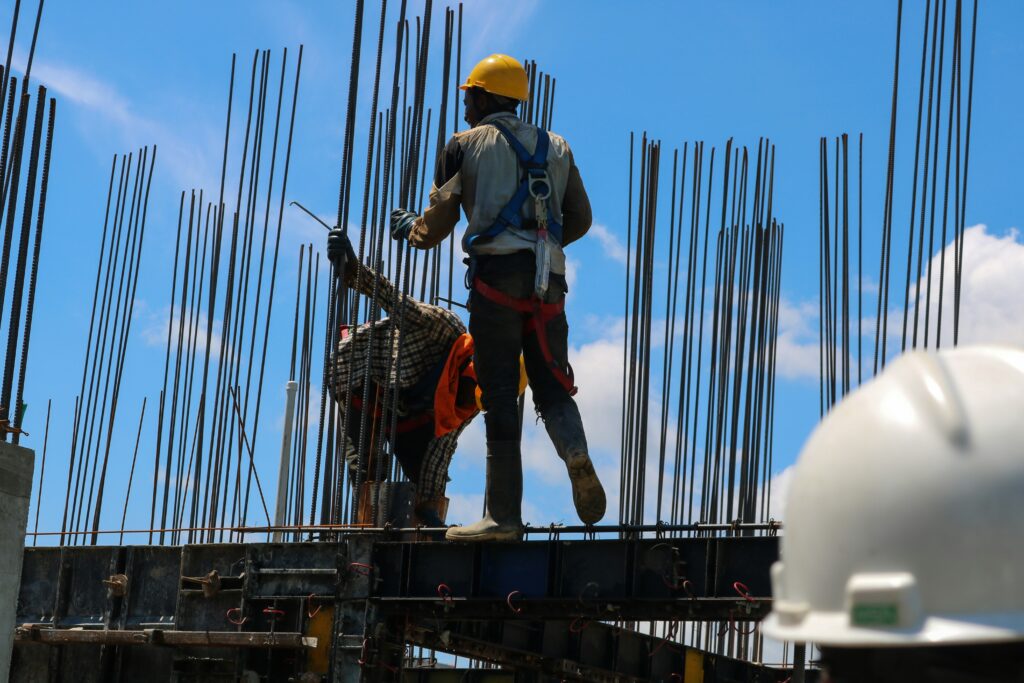 zwei Männer stehen auf Baustelle mit Stahlstreben