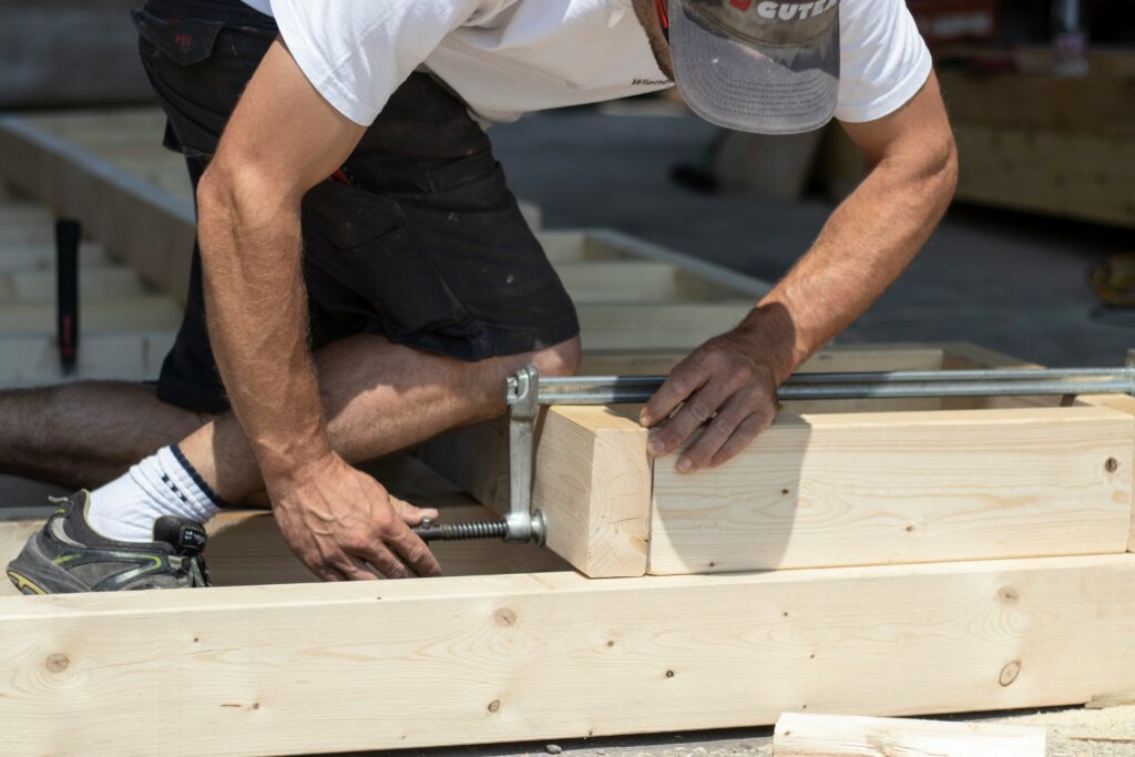 Mann bearbeitet Holzbalken